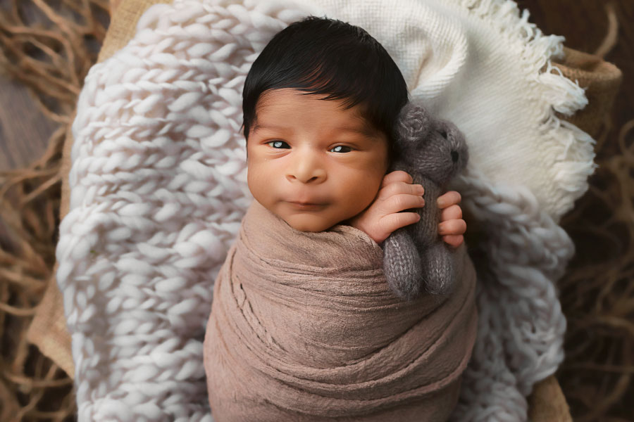 newborn photographer near Fairburn, awake baby boy holding teddy bear