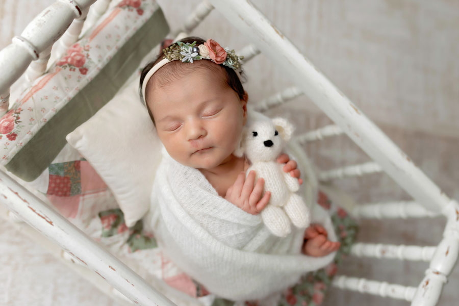 newborn photographer near Hiram, baby girl with quilt and crib prop