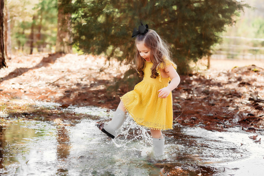 Newnan kids' photographer, girl in rain boots splashing in puddle