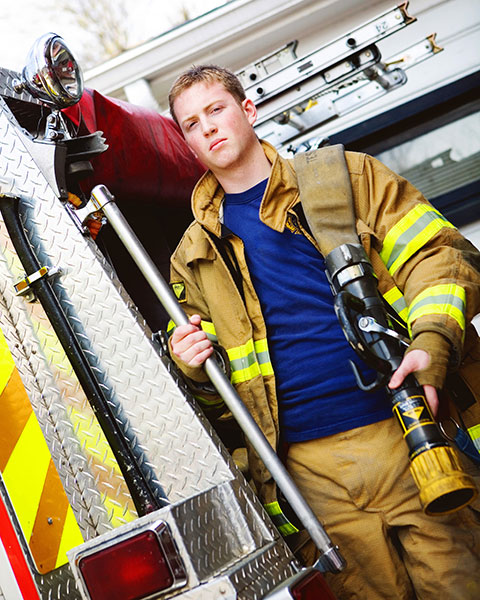 Newnan senior portrait photographer, teen in firefighter gear by fire truck