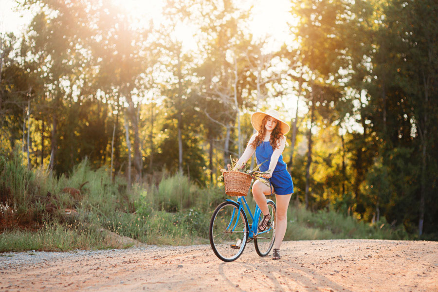 senior portrait photographer near Newnan; teen outside with vintage bicycle