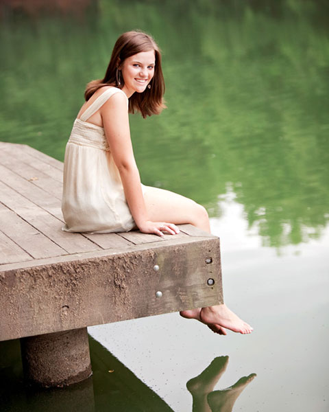 senior portrait photographer near Newnan, teen sitting on dock by water