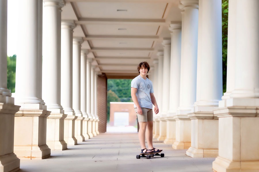 senior portrait photographer near Newnan, teen skateboarding through columns