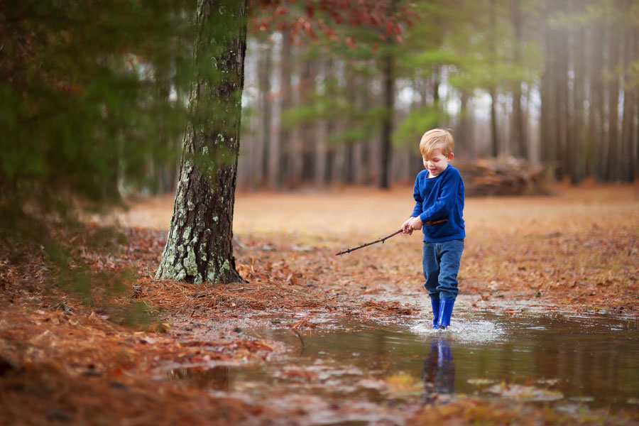 Villa Rica children's photographer, boy playing outside in large puddle
