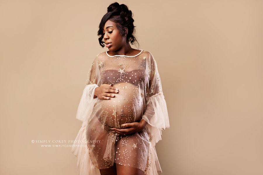 maternity photographer near Atlanta, mom in sheer ruffle dress on light studio backdrop