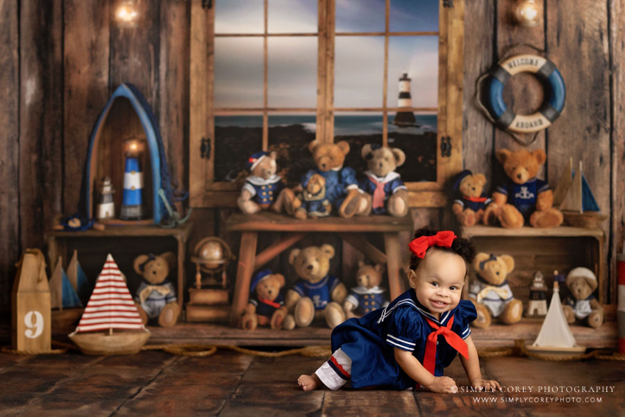Villa Rica baby photographer, girl smiling and crawling on nautical bear studio set
