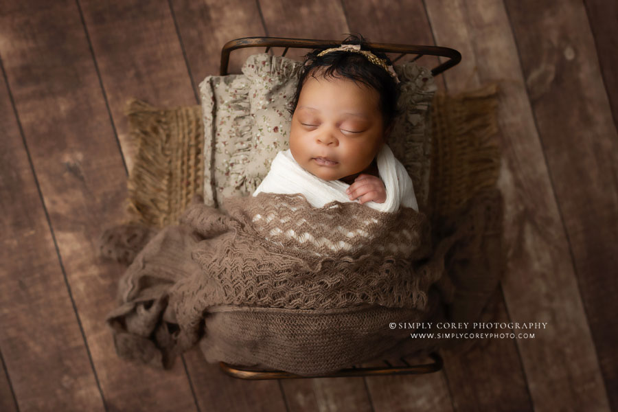 Atlanta newborn photographer, baby girl with brown studio set and bed