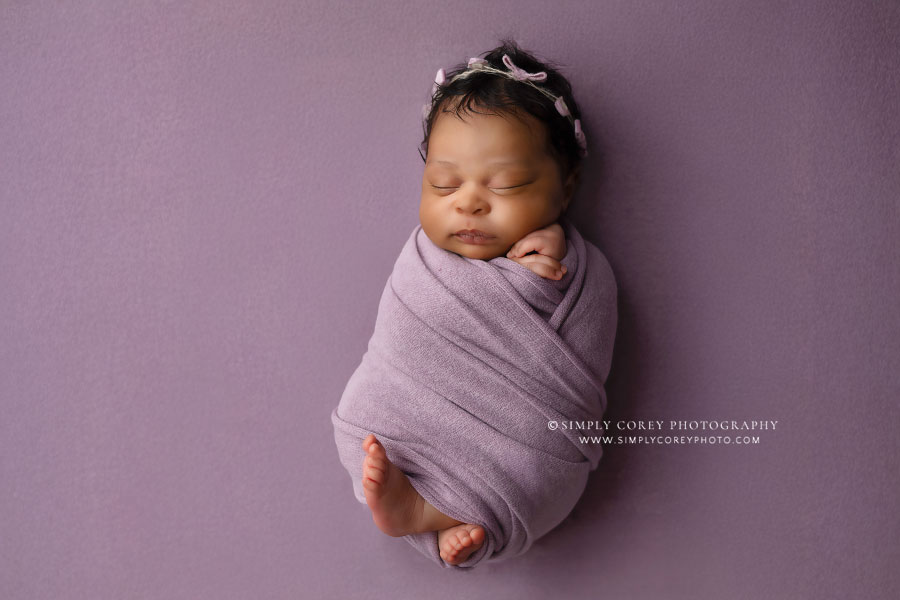 Atlanta newborn photography, baby swaddled in purple during studio session