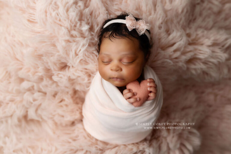 newborn photographer near Atlanta, baby girl on pink flokati with heart in studio