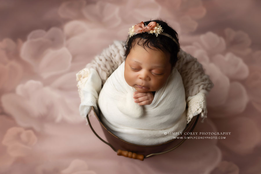 newborn photographer near Newnan, baby girl in bucket on pink studio backdrop