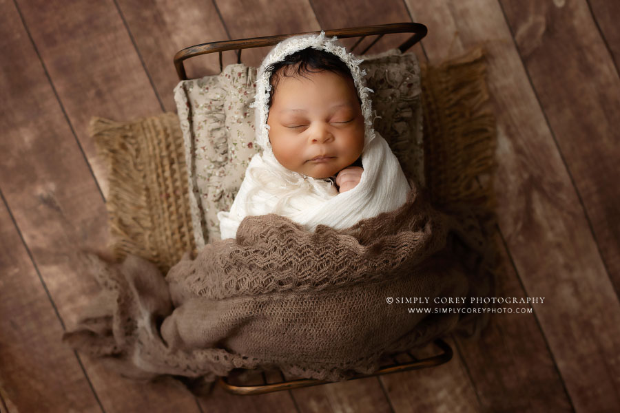 Villa Rica newborn photographer, baby girl in bonnet on brown bed set